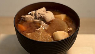 黒い椀に入った、大根や人参、鶏肉の具だくさんな僧兵汁。