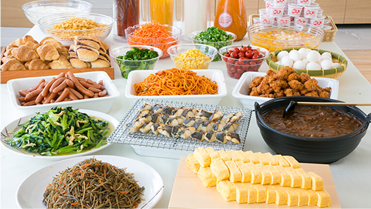和洋の惣菜や卵料理、ソーセージ、パン、麺類などが並ぶ朝食ビュッフェ