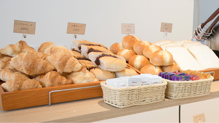 クロワッサンやロールパン、食パンなど種類豊富に並ぶベーカリーコーナー